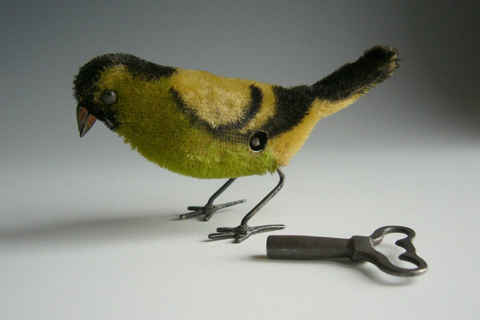 Ein aufziehbarer grüner Vögel mit Aufziehschlüssel