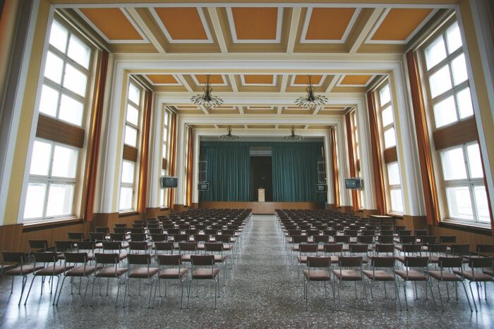 Festsaal der Stasi mit Blick über die Stuhlreihen auf die Bühne