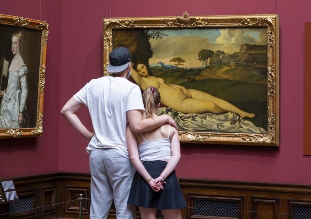 Ein Pärchen betrachtet ein Gemälde mit einer nackten Venus
